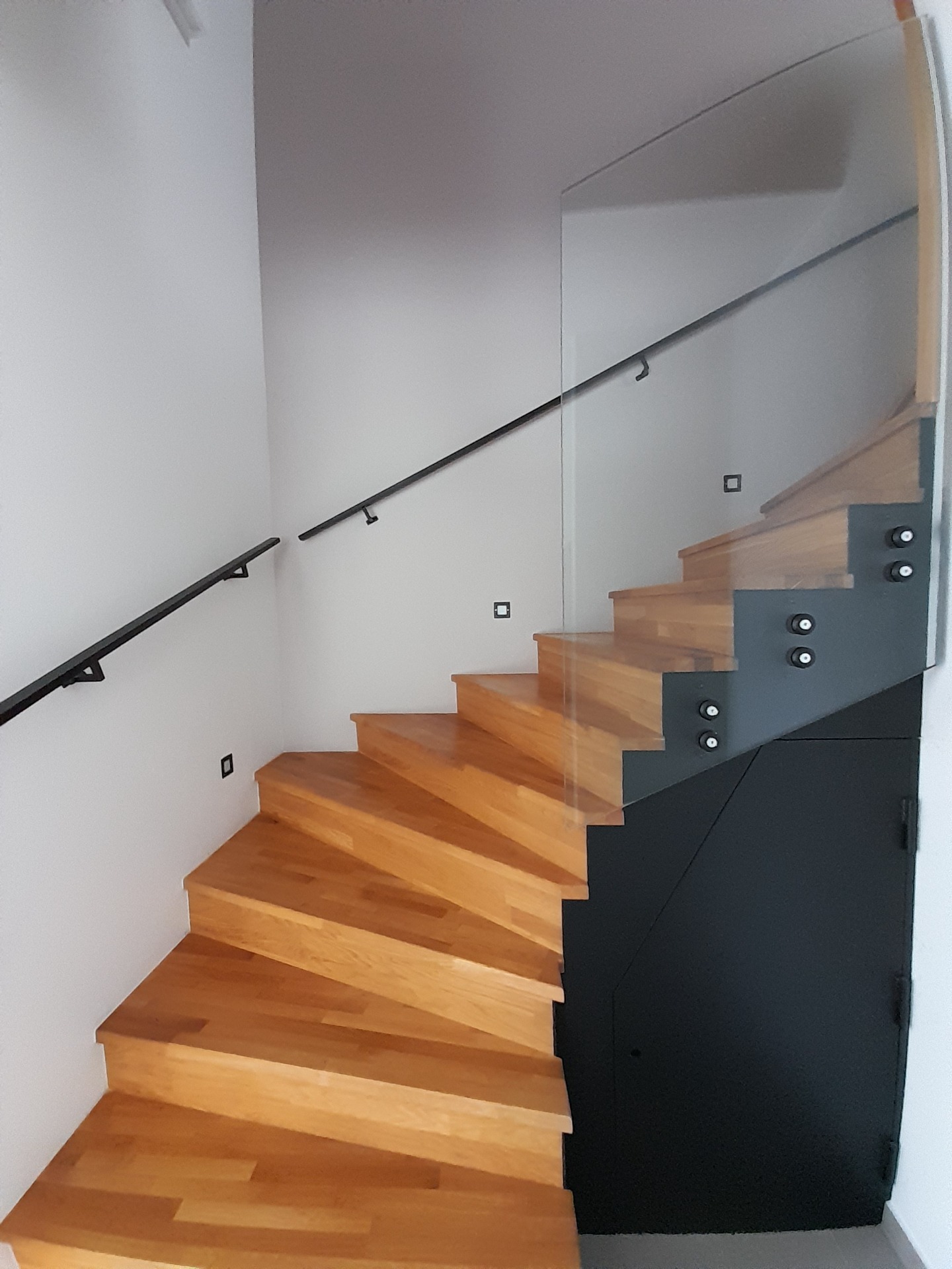 Ocelové krytí schodiště s držením skleněného zábradlí s vestavěnými dvířky + ocelové zábradlí na schody. 