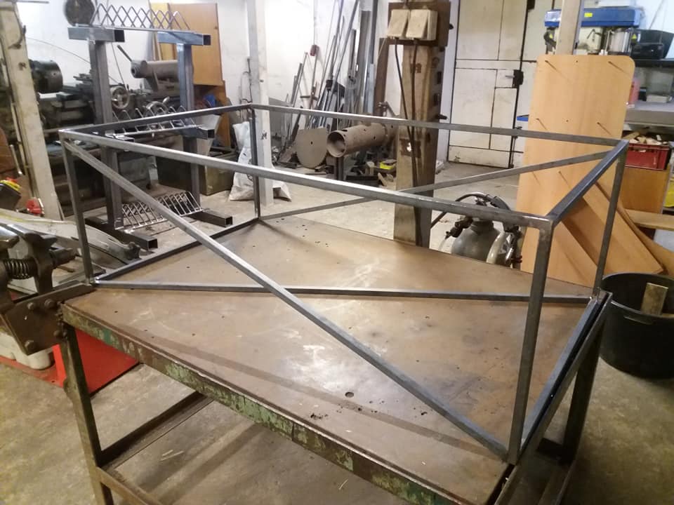 Základ ocelového stolu z plných čtyřhranů jen s povrchovou úpravou lakování. 