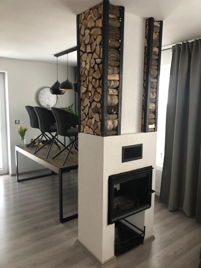 Kovové prvky ke krbu. Ručně kované dekorativní držáky na dřevo.